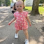 blurred_background, casual, child, cute, daylight, greenery, nature, outdoor, person, pink_clothing, romper, shadows, sidewalk, summer, sunlight, toddler, tree, walking, white_shoes, young_child