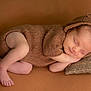 Lucas is registered to the contest to win money with this photo: newborn, baby, sleeping, knitted_outfit, brown, pillow, cozy, infant, cute, peaceful, portrait, resting, soft_lighting, indoors, child, toddler, headwear, face, foot, hand