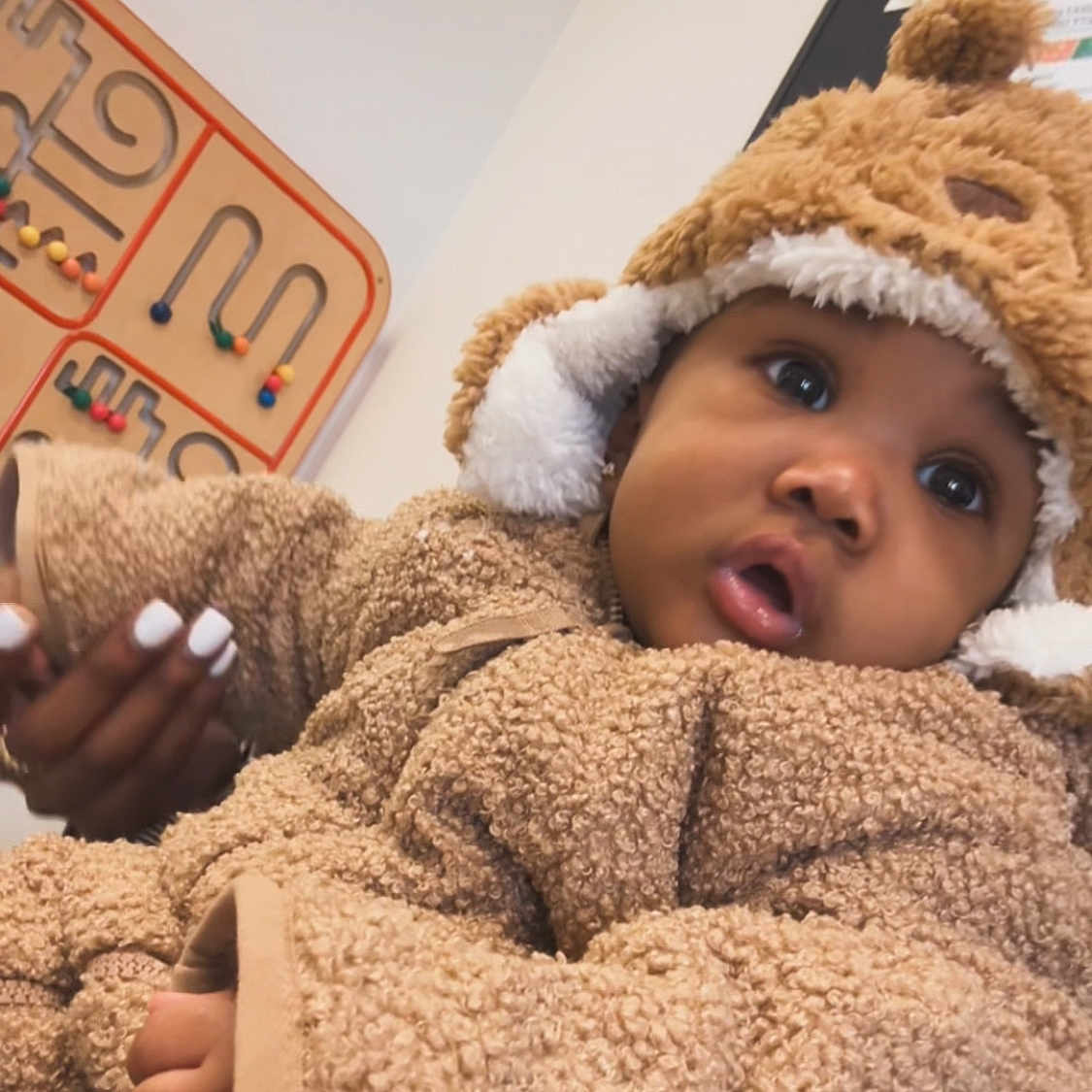 Jahyriaa is registered to the contest to win money with this photo: baby, bead_maze, bear_theme, child, closeup, cozy, curious_expression, cute, fuzzy_clothing, hand, hat, indoor, infant, manicure, person, portrait, soft_texture, wall_art, warm_clothing, wooden_toy