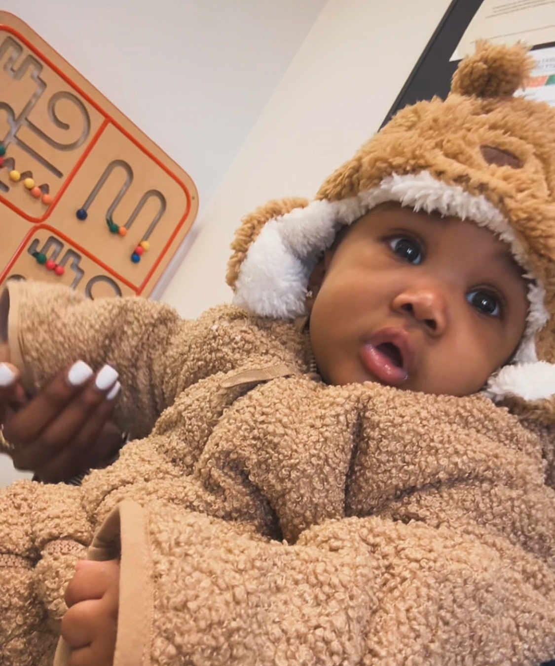 Jahyriaa is registered to the contest to win money with this photo: baby, bead_maze, bear_theme, child, closeup, cozy, curious_expression, cute, fuzzy_clothing, hand, hat, indoor, infant, manicure, person, portrait, soft_texture, wall_art, warm_clothing, wooden_toy