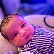 Jacob joined the competition — help win amazing prizes! baby, newborn, infant, face, portrait, striped_clothing, onesie, blanket, sleeping_area, soft_lighting, purple_light, indoor, close_up, cute, skin, head, eyes, young_child, resting, cozy