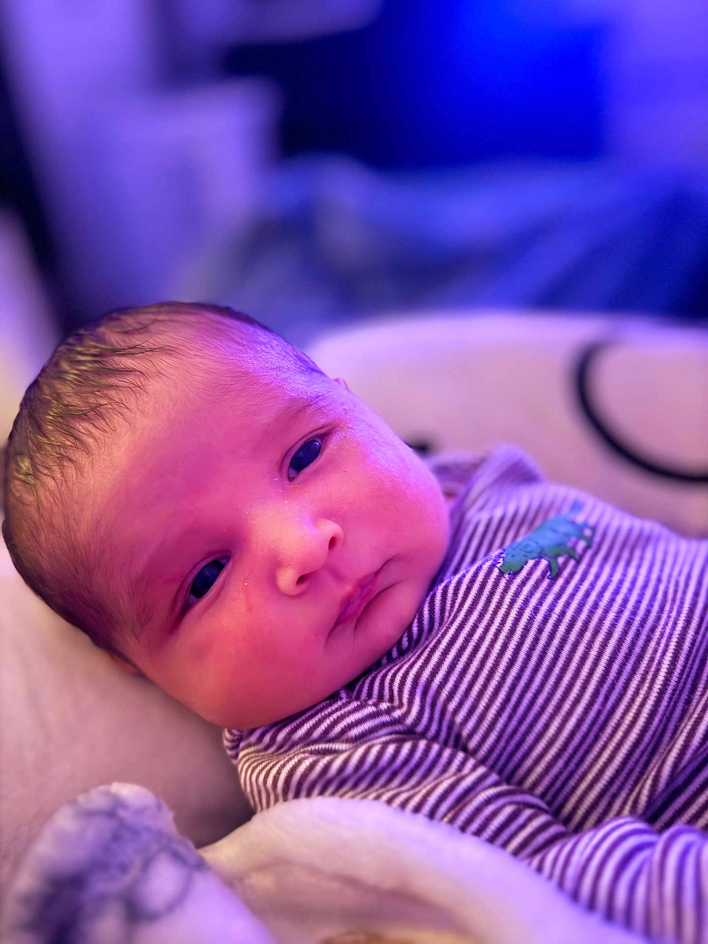 Jacob joined the competition — help win amazing prizes! baby, newborn, infant, face, portrait, striped_clothing, onesie, blanket, sleeping_area, soft_lighting, purple_light, indoor, close_up, cute, skin, head, eyes, young_child, resting, cozy