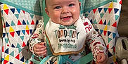 Ainsley joined the competition — help win amazing prizes! baby, smiling, bib, pajamas, mickey_mouse, baby_seat, colorful, festive, happy, child, indoors, seatbelt, holiday_theme, cute, infant, clothing, face, person, portrait, playful