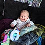 Ainsley is registered to the contest to win money with this photo: baby, smile, blanket, toy, couch, pillow, indoor, child, happy, clothing, face, person, cute, infant, plush, sitting, home, comfort, warm, portrait