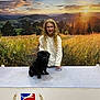 Saint Maxime a rejoint le concours — aidez-le/la à gagner de superbes lots ! girl, child, smile, glasses, long_hair, white_blouse, dog, pug, black_dog, dog_show, table, banner, logo, scenic_backdrop, mountains, field, sunset, indoor, competition, portrait