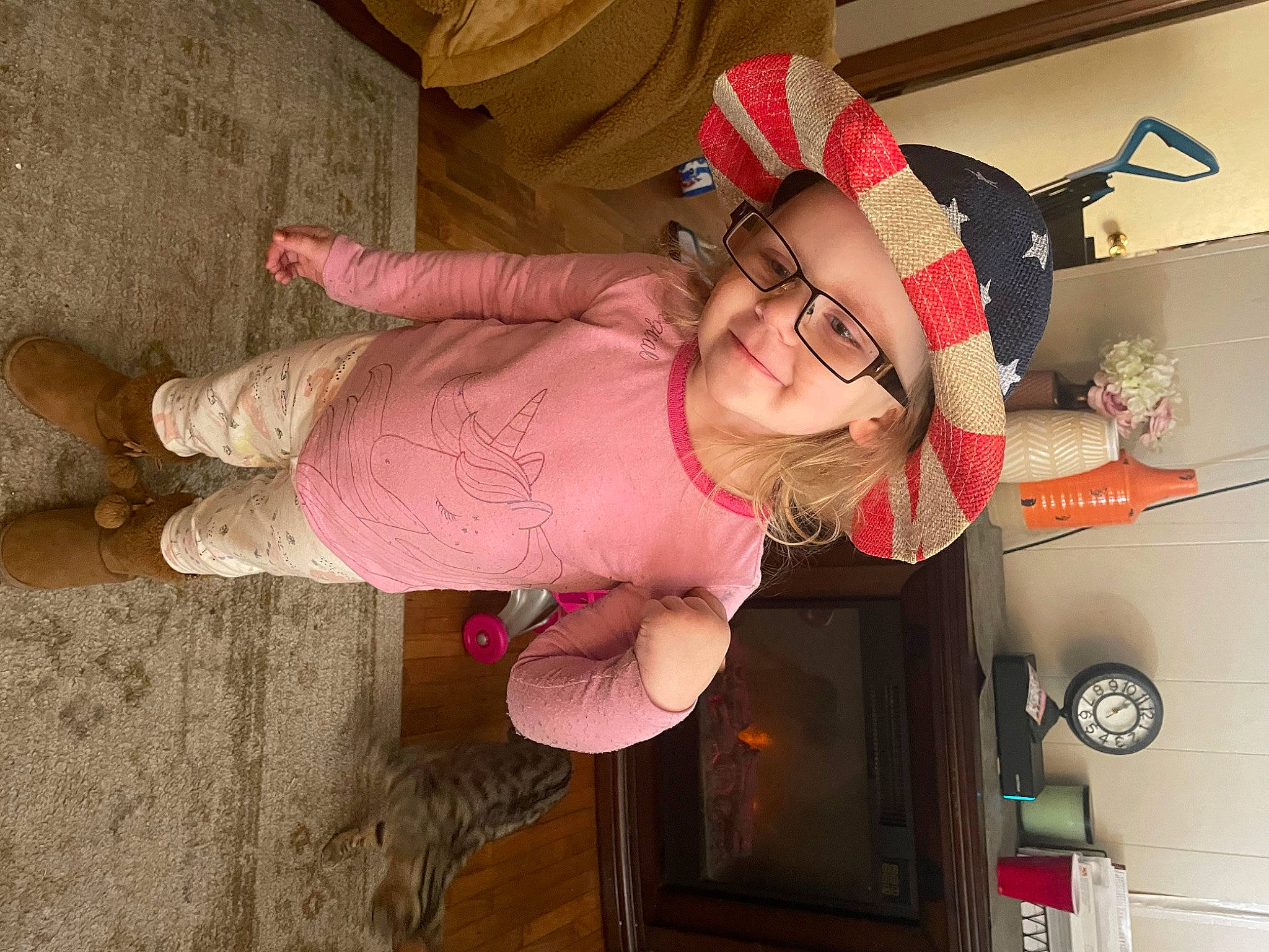 Skyler is registered to the contest to win money with this photo: baby_toddler_clothing, child, costume, eyewear, flesh, fun, happy, hat, headwear, human_leg, joy, magenta, person, pink, room, sandal, smile, thigh, toddler, wood