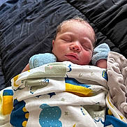 Grayson joined the competition — help win amazing prizes! newborn, baby, sleeping, blanket, mittens, bed, quilt, cozy, infant, peaceful, cute, face, resting, soft, wrapped, child, lying_down, indoors, comfort, portrait