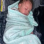Grayson is registered to the contest to win money with this photo: baby, sleeping, blanket, car_seat, child, infant, curly_hair, soft_texture, cozy, comfort, peaceful, wrapped, cute, indoors, seatbelt, protection, portrait, childhood, rest, nap