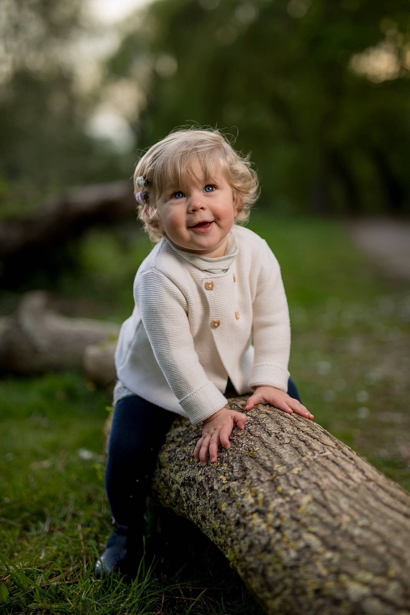 Paola participe au concours pour gagner de l'argent avec cette photo : blond, child, eye, face, flash_photography, forest, fun, grass, happy, head, leisure, people_in_nature, person, plant, sitting, skin, toddler, tree, trunk, wood