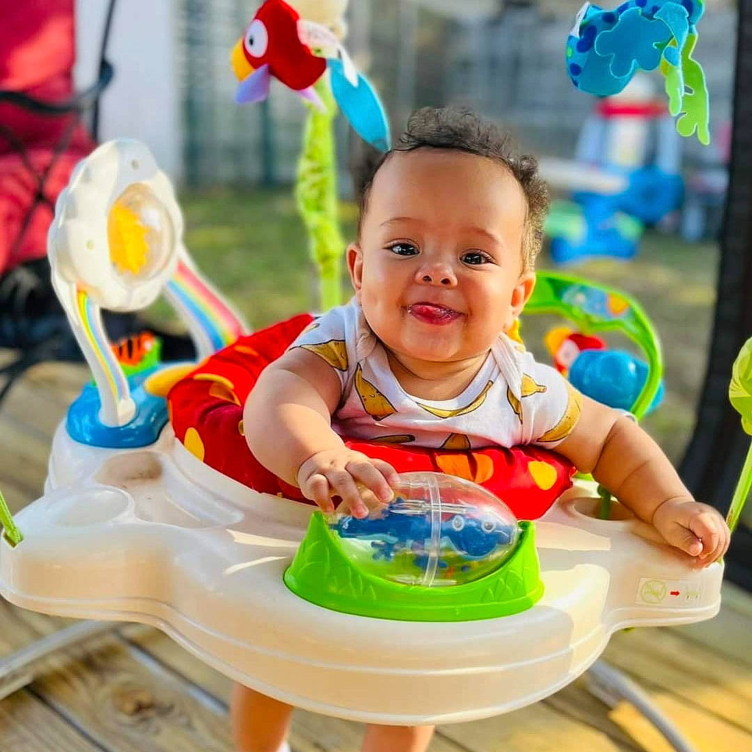 Tobias joined the competition — help win amazing prizes! baby, baby_playing_with_toys, baby_products, baby_toddler_clothing, chair, child, facial_expression, fun, green, happy, joy, leisure, person, product, recreation, riding_toy, smile, table, toddler, toy