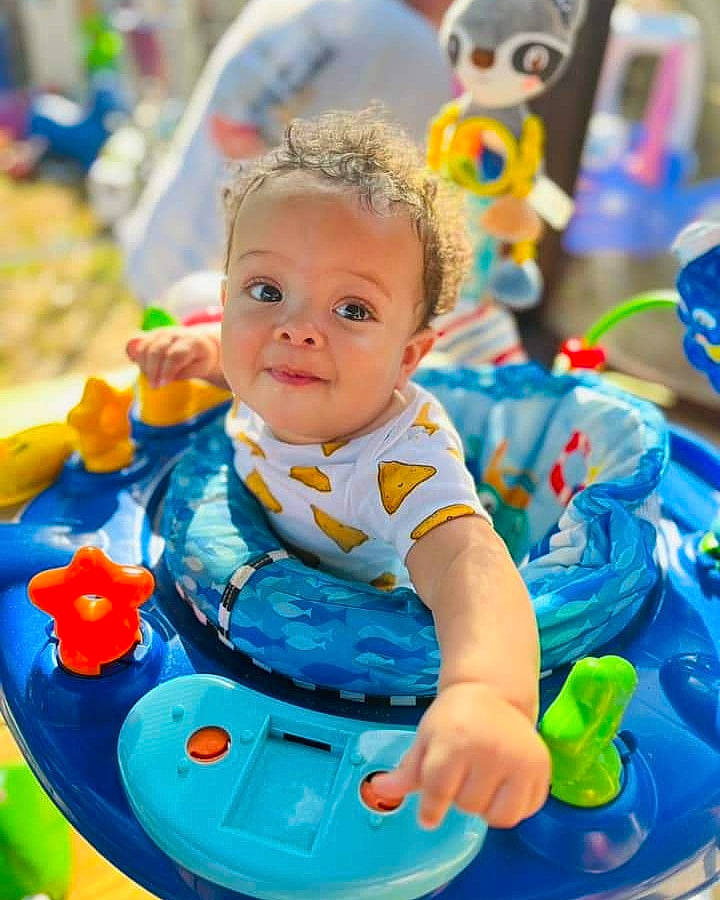 Tobias is registered to the contest to win money with this photo: baby, baby_playing_with_toys, baby_products, baby_toddler_clothing, baby_toys, blue, child, dress, electric_blue, event, fun, grass, happy, leisure, person, product, recreation, sitting, toddler, toy