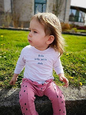 émmy a rejoint le concours — aidez-le/la à gagner de superbes lots ! baby, baby_toddler_clothing, dress, eye, face, facial_expression, grass, hairstyle, happy, iris, lip, people_in_nature, person, pink, plant, skin, sleeve, smile, standing, summer