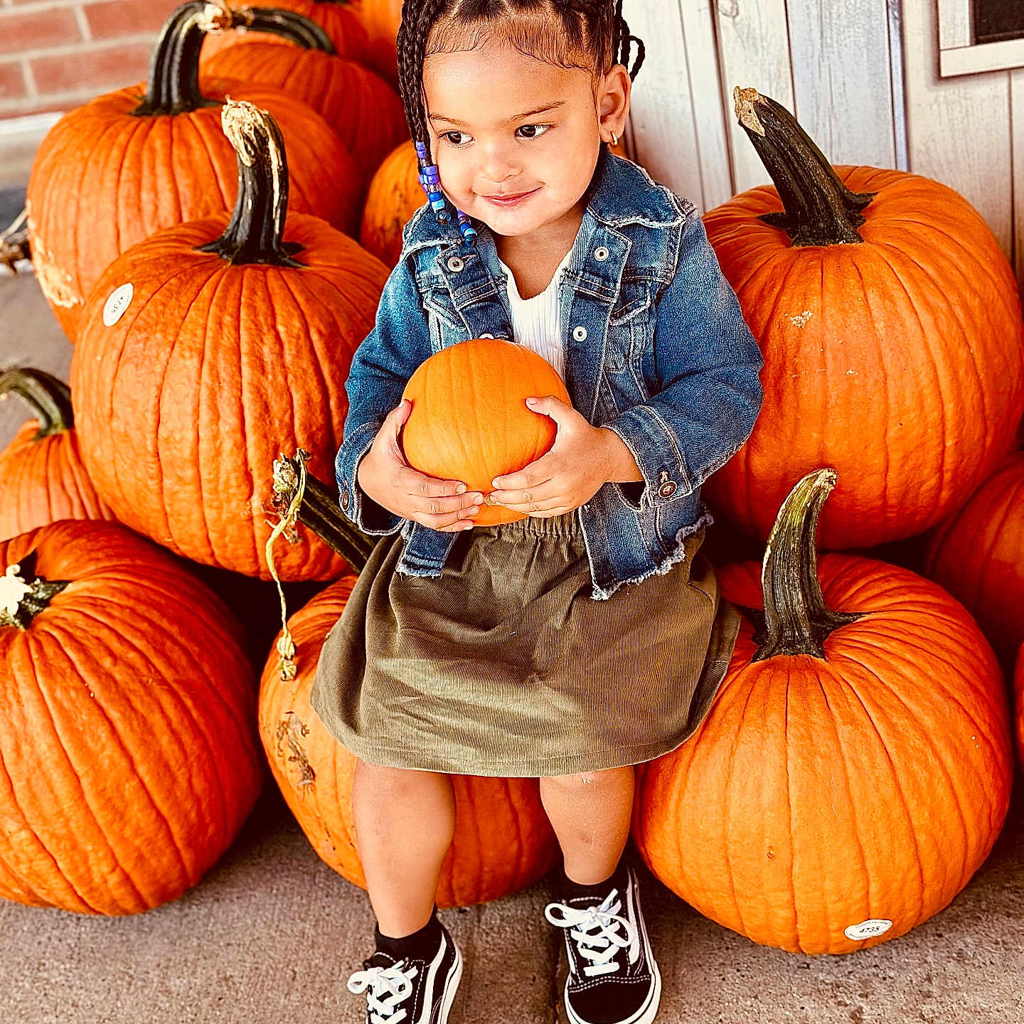 Jayla is registered to the contest to win money with this photo: boy, child, clothing, face, festival, food, footwear, hair, head, male, person, photography, plant, portrait, produce, pumpkin, shoe, sitting, squash, vegetable