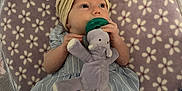 Leona joined the competition — help win amazing prizes! baby, infant, toy, plush_elephant, pacifier, headband, flower, blanket, striped_dress, mesh, playpen, child, cute, lying_down, indoor, soft_toy, hand, legs, pattern, fabric
