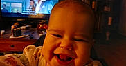 Roselynn joined the competition — help win amazing prizes! baby, candid, child, closeup, clothing, cozy, entertainment, face, furniture, happy, home, indoor, light, living_room, person, screen, smile, table, television, wood