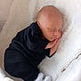 Noam participe au concours pour gagner de l'argent avec cette photo : baby, newborn, sleeping, infant, black_clothing, white_blanket, soft_texture, peaceful, cute, small, cozy, indoors, resting, child, person, footwear, sock, portrait, lying_down, hand_near_face