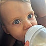 baby, bottle, milk, blue_eyes, face, close_up, car_seat, child, infant, hand, skin, hair, feeding, expression, cute, young_child, portrait, comfort, seatbelt, curious