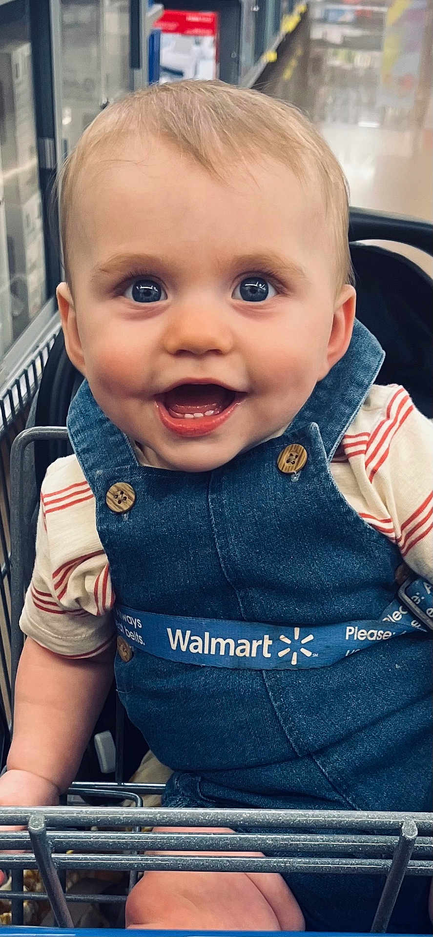 Samuel joined the competition — help win amazing prizes! baby, child, smiling, shopping_cart, denim_overalls, blue_eyes, button, striped_shirt, walmart, grocery_store, happy, cute, infant, retail, retail_store, person, seatbelt, safety, indoor, closeup