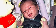 Kamila is registered to the contest to win money with this photo: baby, infant, car_seat, plush_toy, winnie_the_pooh, yellow_outfit, mittens, baby_toy, child, seat_belt, safety_harness, floral_pattern, cute, indoors, smiling, foot, head, face, person, soft_toy