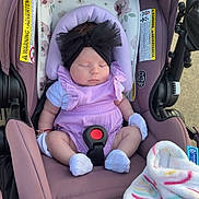 Kamila is registered to the contest to win money with this photo: baby, infant, sleeping, car_seat, headband, black_bow, purple_clothing, romper, blanket, floral_pattern, soft_toys, outdoor, child, cute, newborn, socks, safety_harness, peaceful, resting, pink