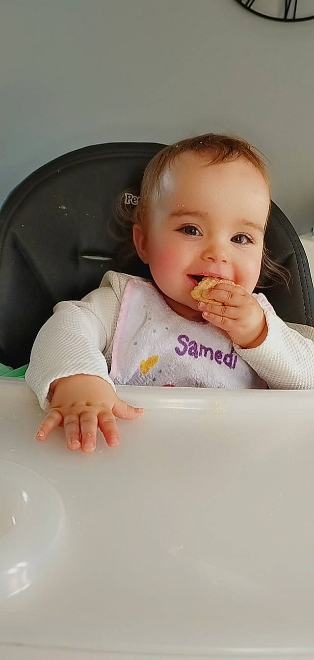 Kélya participe au concours pour gagner de l'argent avec cette photo : arm, baby, baby_toddler_clothing, cheek, child, comfort, dishware, drinkware, eyelash, finger, gesture, hand, happy, joy, lip, nose, person, sitting, skin, sleeve