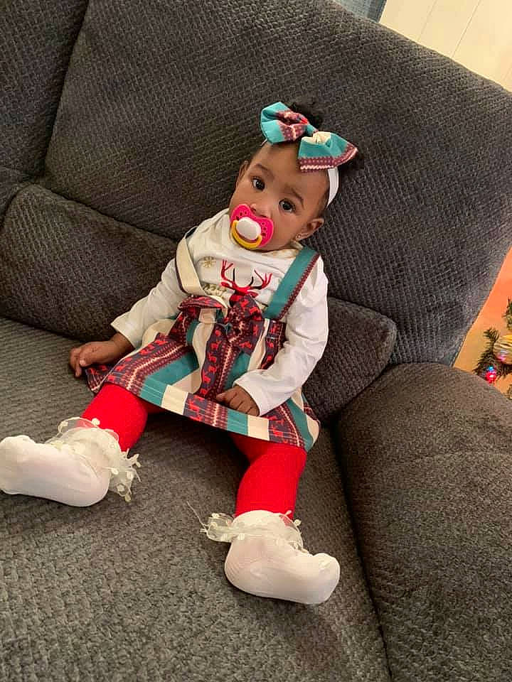 Kaylen joined the competition — help win amazing prizes! armrest, baby, baby_toys, christmas, costume_accessory, costume_hat, couch, doll, fictional_character, fur, living_room, person, plush, slipcover, sock, stuffed_toy, throw_pillow, toy