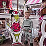 child, boy, smiling, indoor, holiday, christmas, grinch, cutout, decorations, candy, shop, flooring, clothing, sneakers, display, festive, toy, portrait, standing, happy