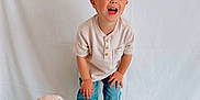 Liam joined the competition — help win amazing prizes! barefoot, boy, casual_clothing, child, cute, dog_toy, happy, indoor, jeans, light, playful, plush_toy, portrait, shirt, smiling, standing, stuffed_animal, toddler, white_background, young