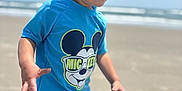 Liam is registered to the contest to win money with this photo: beach, blue_shirt, casual_clothing, child, fun, hands, happy, mickey_mouse, ocean, outdoor, play, portrait, sand, shorts, sky, smiling, summer, sunny, toddler, vacation