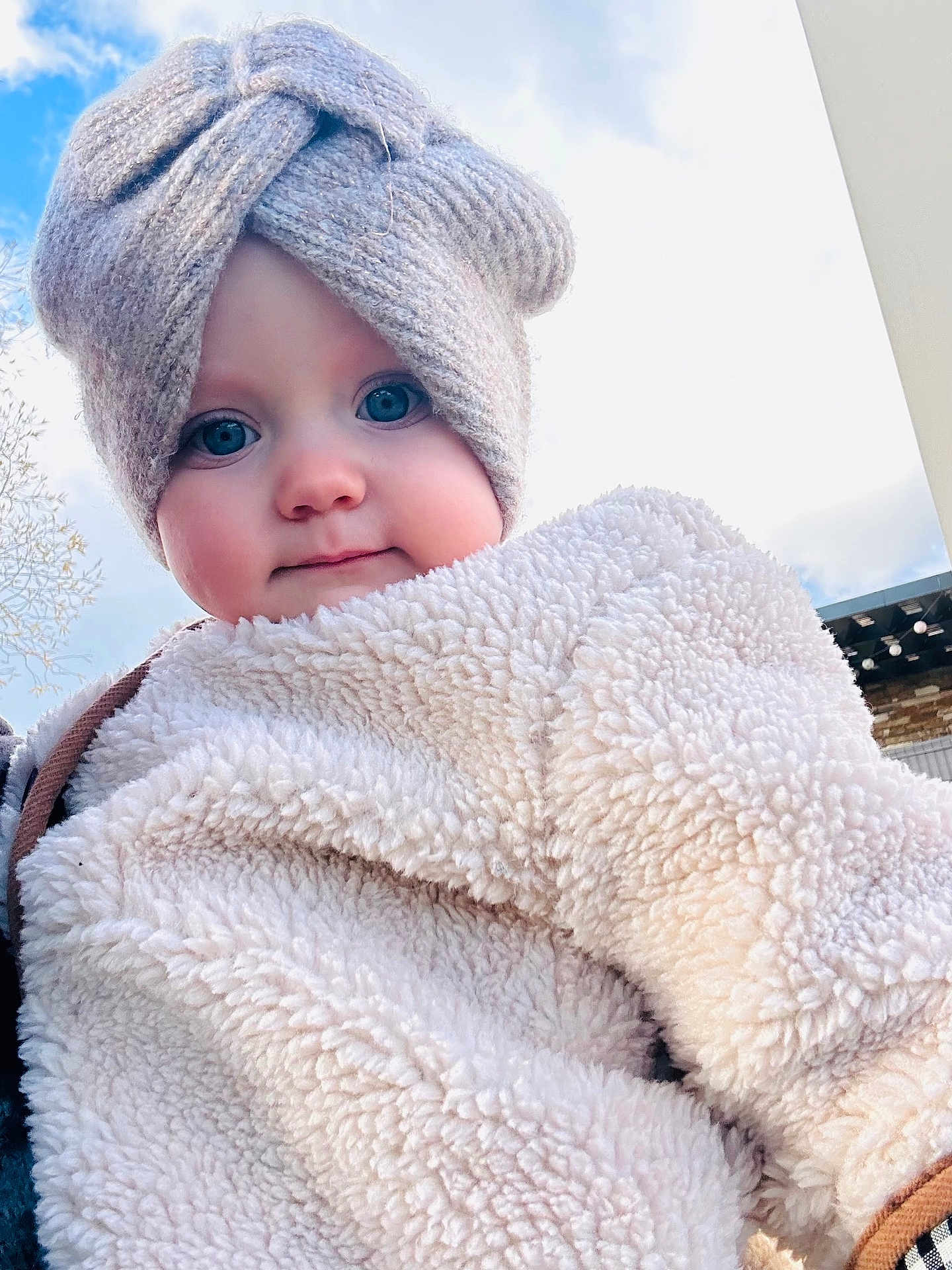 Louise a rejoint le concours — aidez-le/la à gagner de superbes lots ! baby, child, face, blue_eyes, knit_hat, bow, fluffy_jacket, winter_clothing, outdoor, sky, portrait, cute, warm_clothing, infant, headwear, soft_texture, smile, person, close_up, daylight