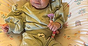 Kyara is registered to the contest to win money with this photo: baby, infant, child, portrait, lying_down, smiling, wide_eyed, bow_headband, green_outfit, pacifier, baby_toy, stuffed_animal, patterned_blanket, baby_bouncer, indoor, close_up, adorable, relaxed, textile, family_photo