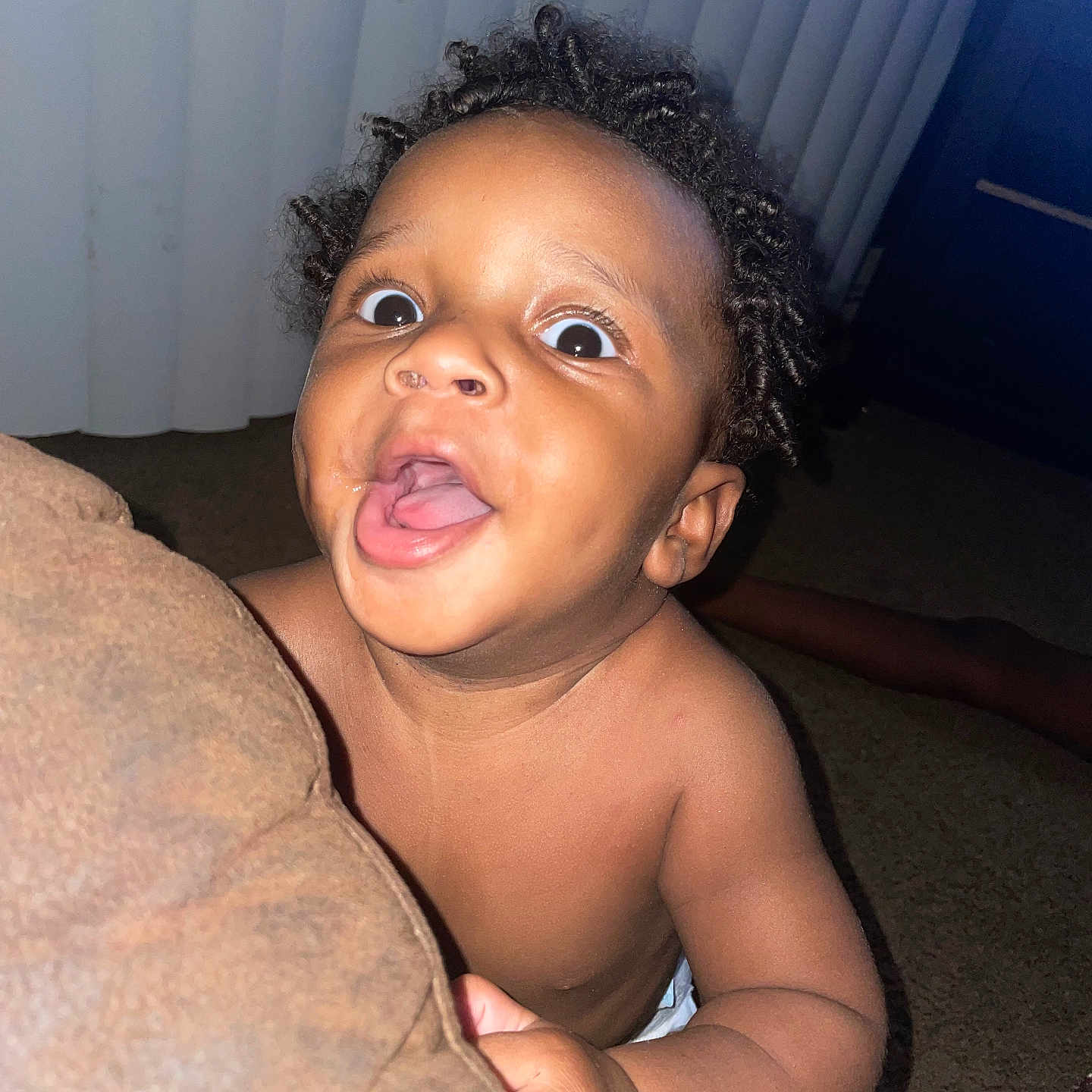 Taevion is registered to the contest to win money with this photo: baby, bare_chest, carpet, child, curly_hair, cushion, excited, expression, face, hand, indoor, looking_up, mouth_open, peeking, portrait, room, skin, vertical_blinds, wide_eyes, young_child