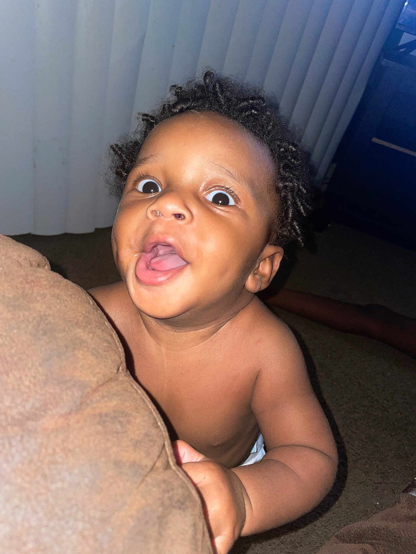 Taevion is registered to the contest to win money with this photo: baby, child, indoor, carpet, curly_hair, cushion, expression, face, hand, looking_up, mouth_open, peeking, portrait, room, skin, vertical_blinds, young_child, excited, wide_eyes, bare_chest