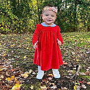 Hannah is registered to the contest to win money with this photo: child, toddler, red_dress, headband, flower, smile, outdoor, autumn, leaves, forest, nature, standing, white_shoes, grass, sunlight, happy, young_child, seasonal, cute, portrait