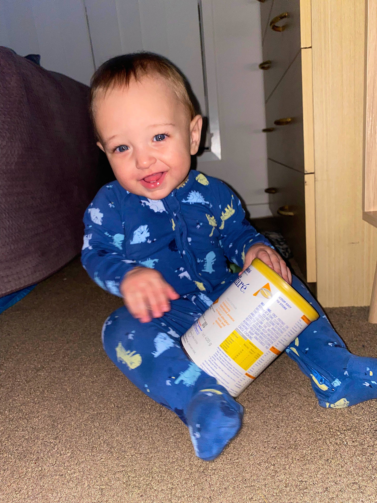 Benjamin is registered to the contest to win money with this photo: baby, baby_toddler_clothing, cabinetry, child, comfort, couch, door, electric_blue, floor, flooring, fun, happy, hardwood, joy, person, play, room, sitting, sleeve, smile
