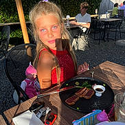 Raisa a rejoint le concours — aidez-le/la à gagner de superbes lots ! child, girl, outdoor, table, food, plate, toy_cars, doll, red_dress, sunlight, shadow, restaurant, people, glass, fork, knife, napkin, hedge, chair, casual