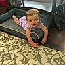 baby, child, smile, purple_clothing, dog_bed, carpet, wood_floor, table, home_interior, basket, earrings, happy, person, floor, indoor, furniture, crawling, cute, infant, plush