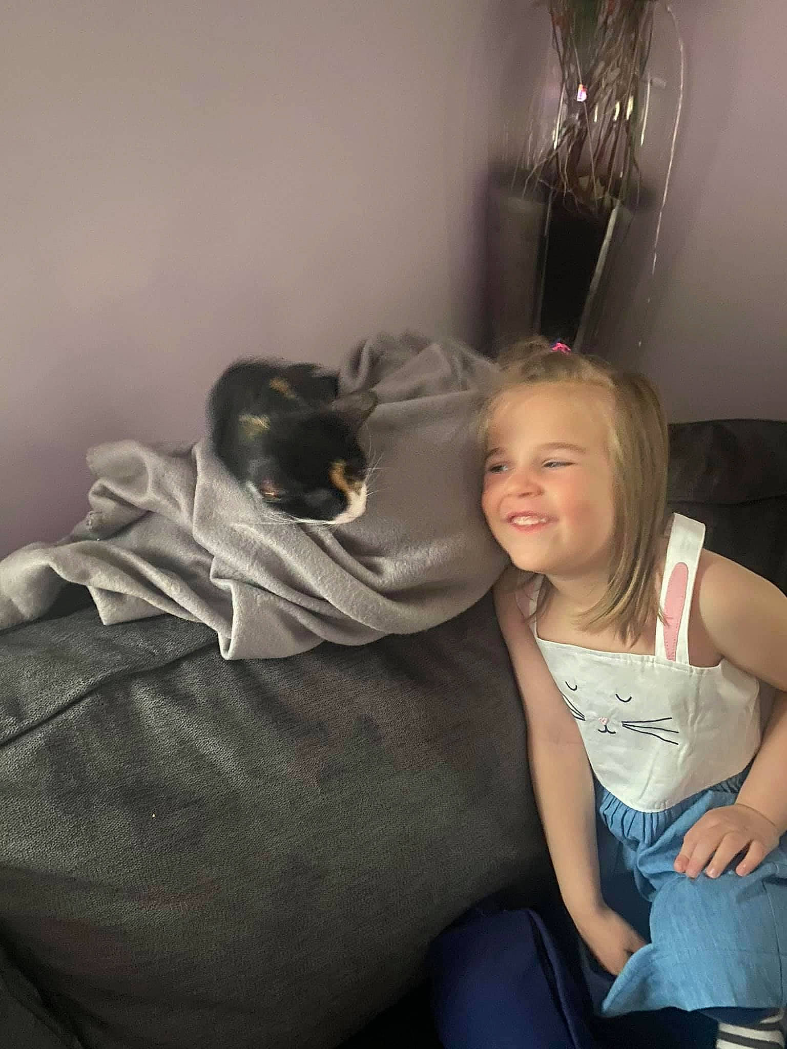 Isabella is registered to the contest to win money with this photo: blond, comfort, couch, event, flash_photography, fun, fur, gesture, happy, human_leg, joy, knee, lap, laugh, leg, person, room, sitting, smile, t_shirt