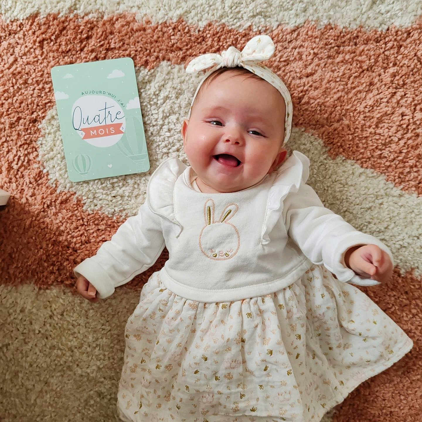Ellie participe au concours pour gagner de l'argent avec cette photo : accessories, baby, babylaughing, clothing, dress, face, happy, hat, head, homedecor, jewelry, laughing, necklace, newborn, person, photography, portrait, sitting, skirt, smile