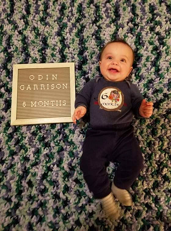 Odin is registered to the contest to win money with this photo: baby, baby_toddler_clothing, brown, child, flooring, font, grass, happy, illustration, linens, pattern, people_in_nature, person, portrait_photography, product, room, sleeve, sportswear, t_shirt, toddler