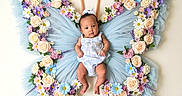 Kaiyah is registered to the contest to win money with this photo: adorable, baby, blue, butterfly_wings, child, costume, cute, floral_arrangement, flowers, green_leaves, infant, knitted_antennae, pastel_colors, pink, portrait, purple, soft_texture, tulle, whimsical, white