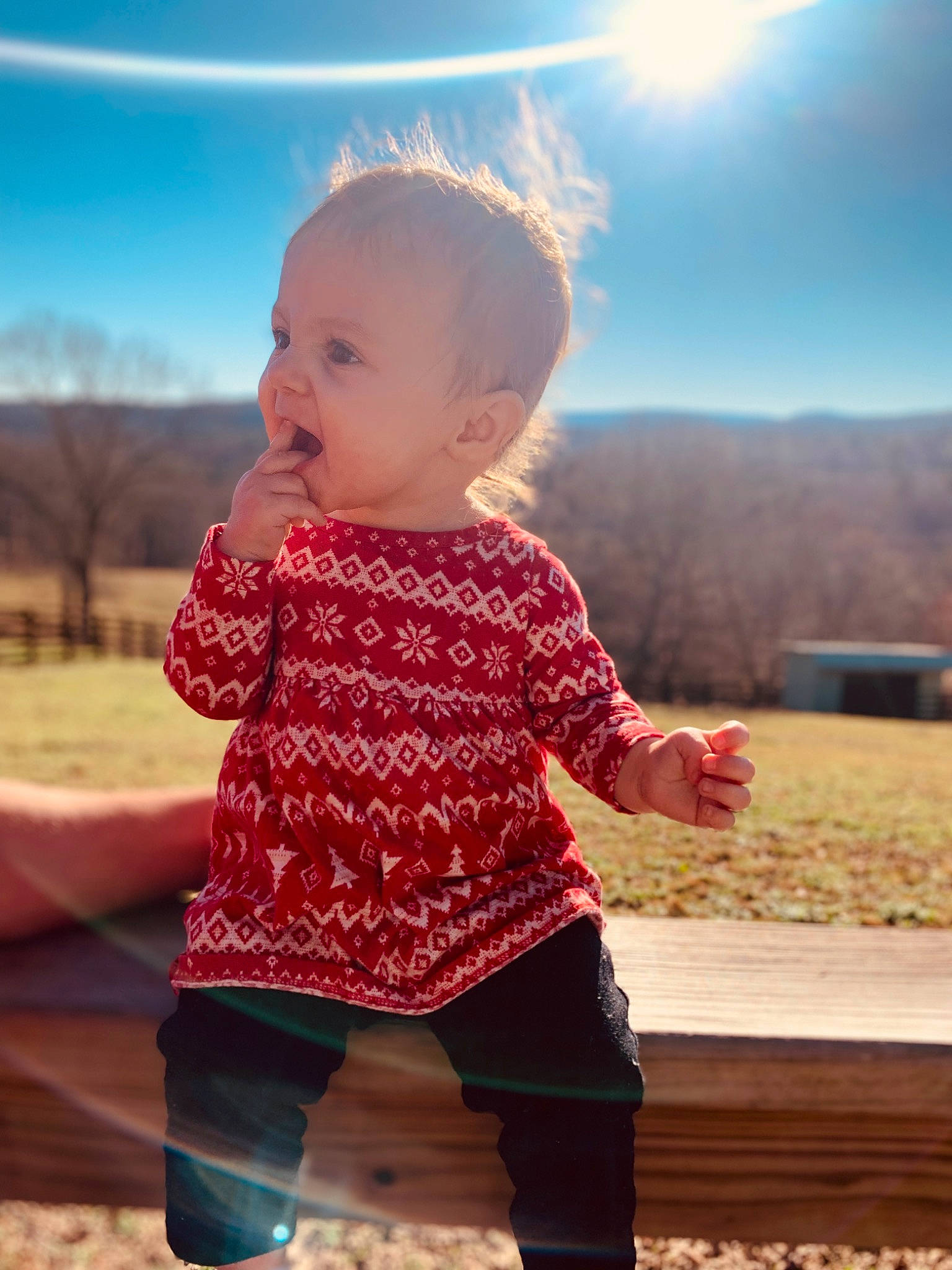 Nevaeh is registered to the contest to win money with this photo: baby, baby_toddler_clothing, face, facial_expression, fun, gesture, happy, head, human, light, outerwear, people_in_nature, person, plant, shoulder, skin, sky, sleeve, standing, sunlight
