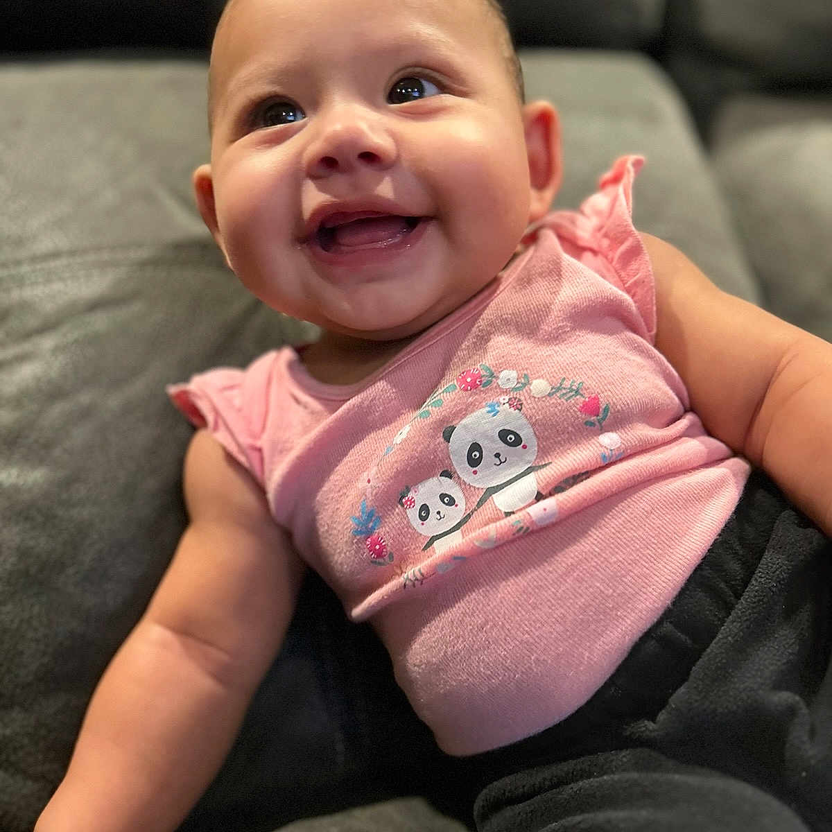 Leilani is registered to the contest to win money with this photo: baby, babylaughing, bodypart, clothing, couch, cushion, face, furniture, happy, head, homedecor, laughing, newborn, pants, person, photography, portrait, sitting, smile, t_shirt