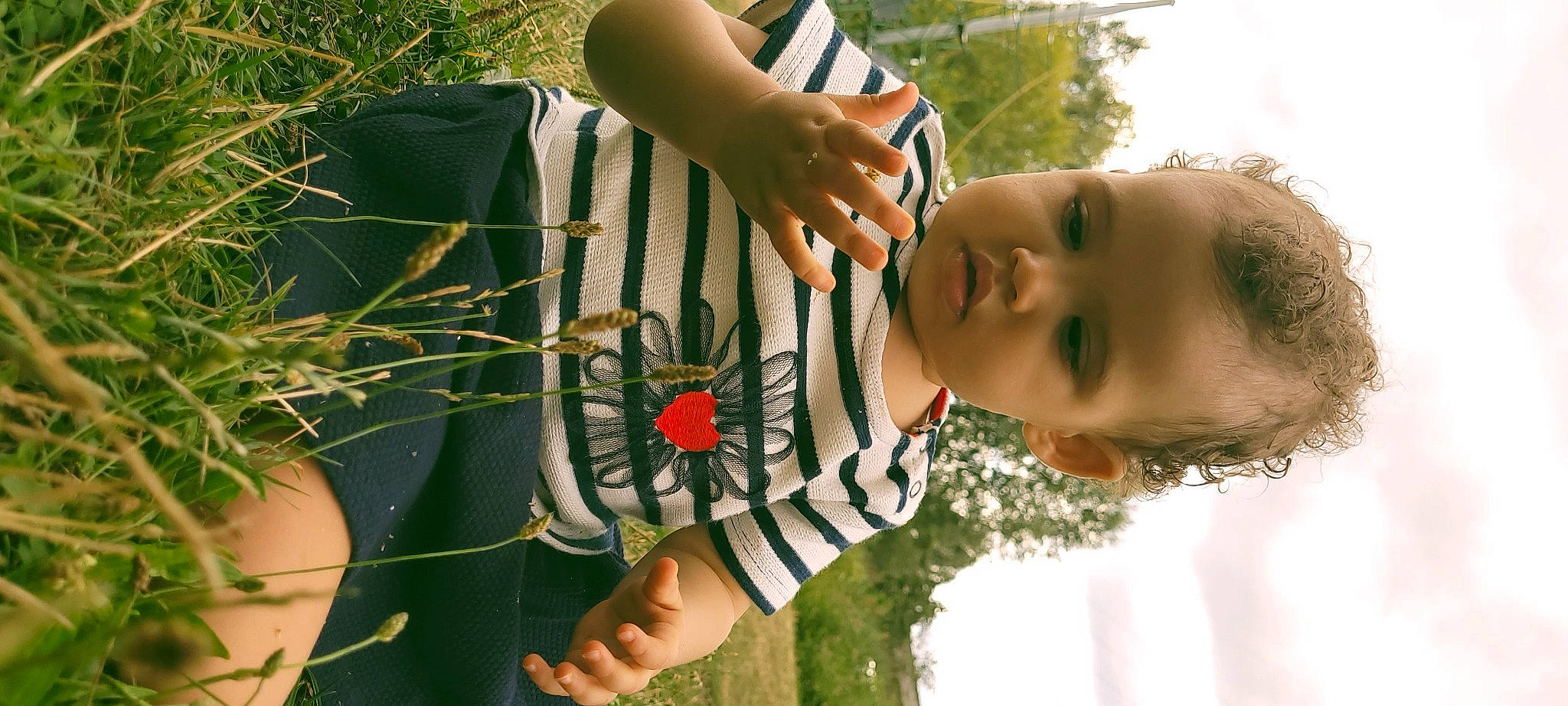 Naelle participe au concours pour gagner de l'argent avec cette photo : adaptation, arm, elbow, finger, gesture, grass, grass_family, green, hand, happy, joint, leisure, pattern, people_in_nature, person, plant, summer, t_shirt, thumb, toddler