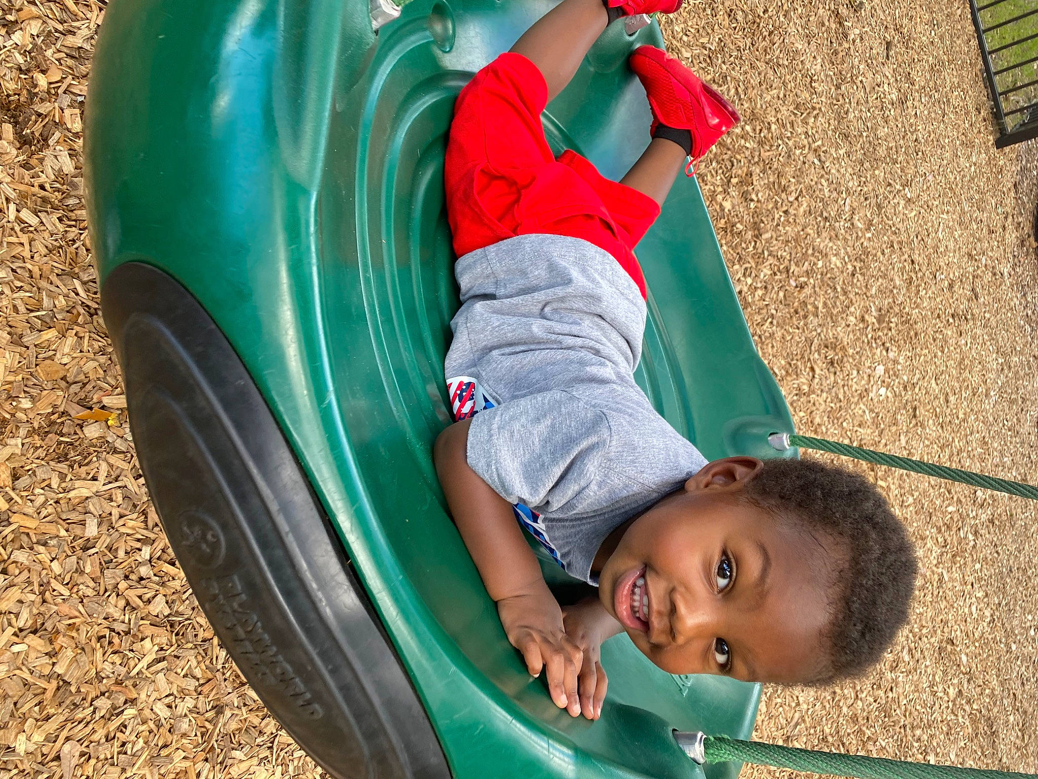 Malachi is registered to the contest to win money with this photo: automotive_exterior, automotive_tire, automotive_wheel_system, bumper, fender, fun, grass, green, jeans, leisure, motor_vehicle, person, plant, playground, playground_slide, swing, tire, toddler, tree, vehicle_door