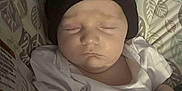 David is registered to the contest to win money with this photo: baby, beanie, blanket, child, closeup, cozy, cushion, cute, face, hand, indoor, infant, leaf_pattern, pattern, peaceful, resting, sleeping, soft_toys, white_shirt, young_child