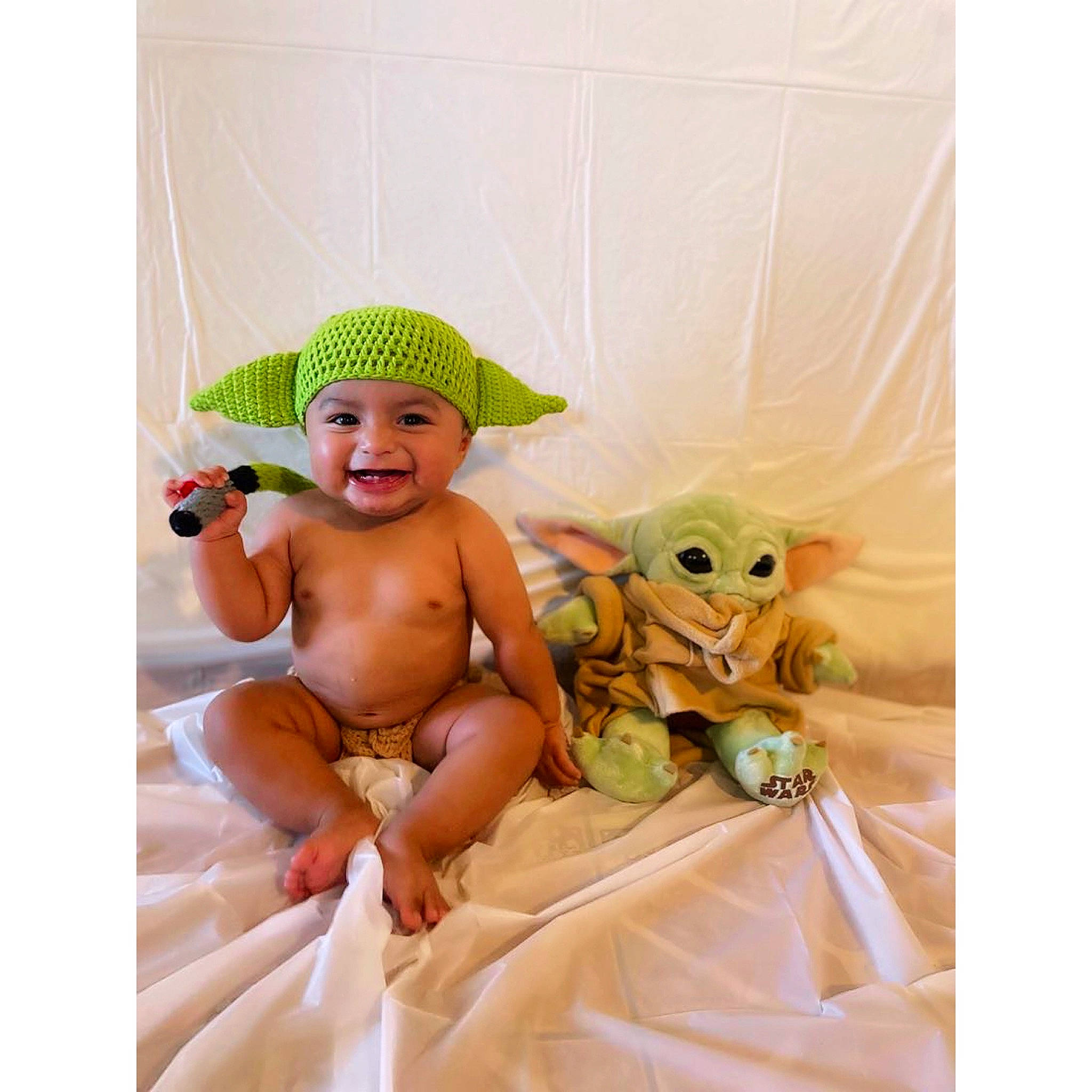 Gael is registered to the contest to win money with this photo: abdomen, baby, baby_products, baby_safety, baby_toddler_clothing, bed, cap, child, comfort, diaper, event, happy, hat, headwear, joy, linens, person, room, smile, stuffed_toy
