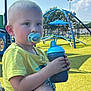 Weston is registered to the contest to win money with this photo: child, toddler, pacifier, sippy_cup, playground, yellow_turf, blue_climbing_structure, outdoor, sunny, sky, shorts, yellow_shirt, summer, daytime, person, cute, play, recreation, park, casual