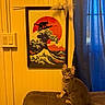 cat, kitten, couch, yellow_wall, framed_art, wall_art, black_cat_silhouette, wave, sun, blue_curtain, indoor, furniture, pet, tabby, curious, sitting, brown_couch, decor, home, cozy