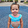 Maggie is registered to the contest to win money with this photo: blue, child, cute, daylight, fun, girl, hair_tie, outdoor, park, pink, playground, recreation, rubber_surface, smile, standing, summer, swimsuit, toddler, wet_hair, young_child